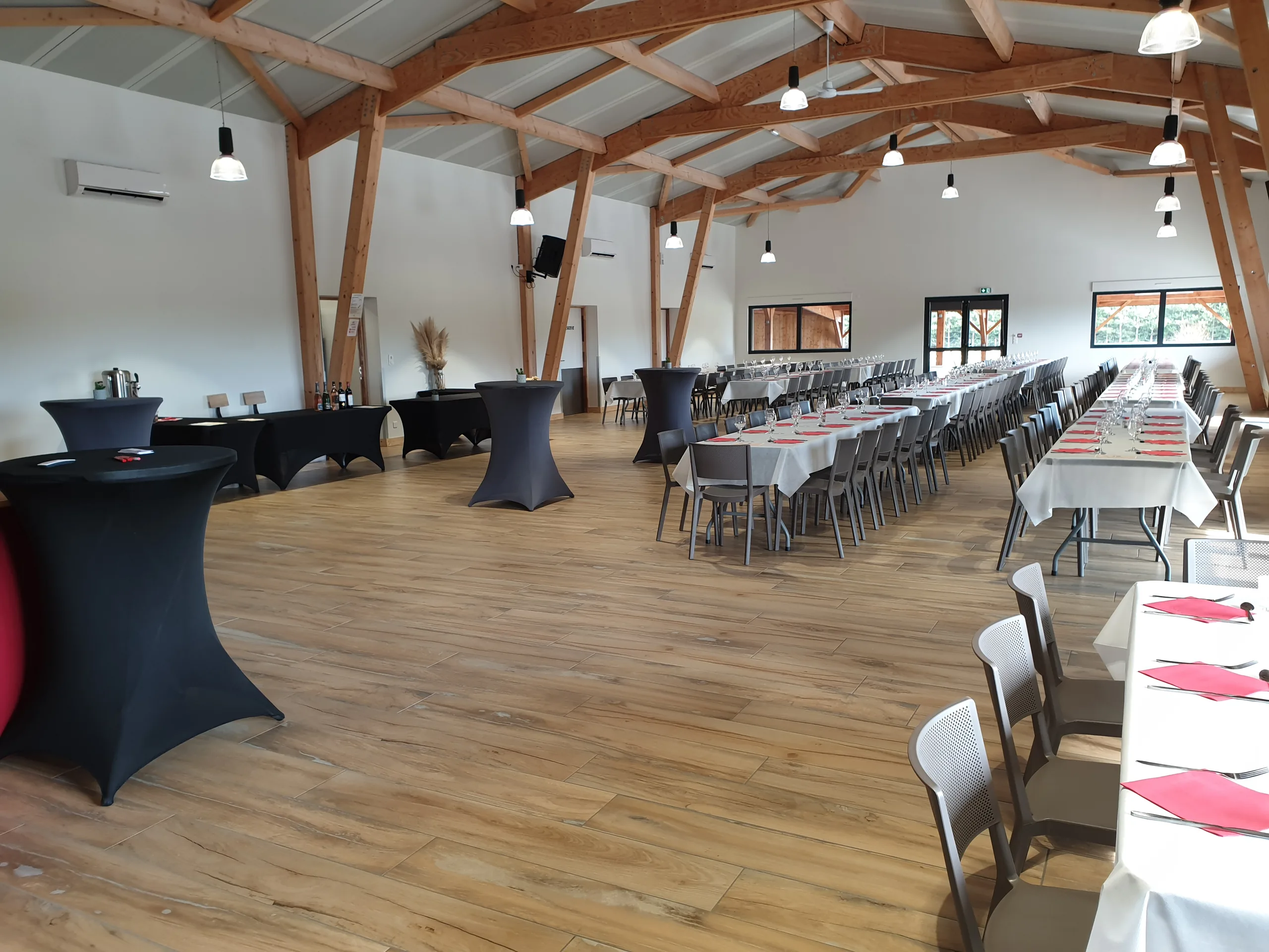 Grandes tablées de banquet dressées dans la salle de réception